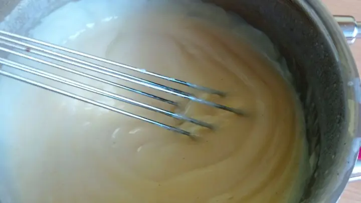 Der fertig gekochte Vanillepudding kann etwas abkühlen und wird dann mit dem Eischnee vermischt.