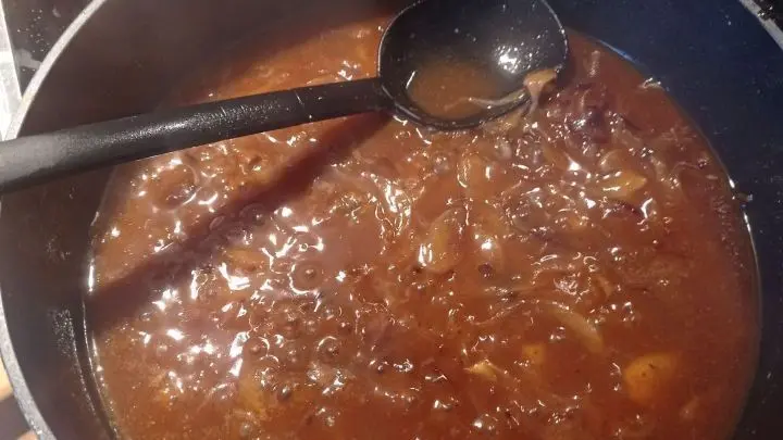 Die Zwiebelsoße wird in der Pfanne des Hackbratens zubereitet, indem die Zwiebeln im Fett angebraten werden.