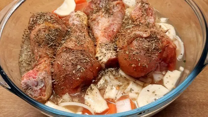 Alles fertig geschichtet und zuoberst sind die kleinen Hähnchenkeulen sichtbar. Man darf gespannt sein. Saftige Hähnchenkeulen im Ofen, auf Gemüse und Reis gebettet – so gelingt das einfache, aromatische Ofengericht Schritt für Schritt.