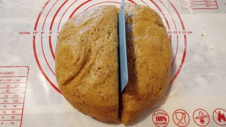 Ich knete den Teig nochmals mit den Händen kurz durch und teile ihn dann in zwei Teile und dazu benutze ich eine Teigkarte. Ich knete den Teig nochmals mit den Händen kurz durch und teile ihn dann in zwei Teile und dazu benutze ich eine Teigkarte.