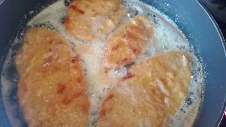 Knuspriges Schnitzel brutzelt in der Pfanne in Butterschmalz &ndash; Fleischbeilage zu Spargel mit Bozner Sauce.