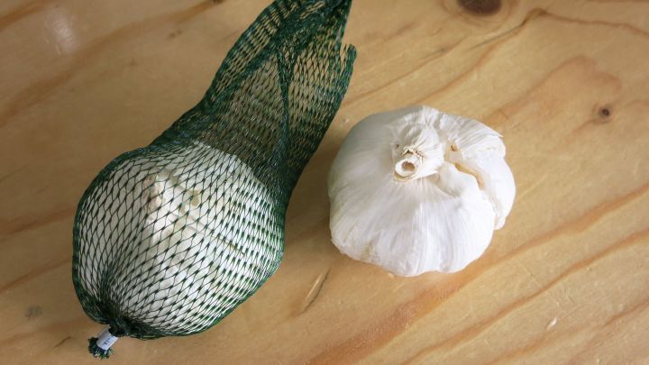 Leichtes Schälen von Knoblauch mithilfe eines Gummiverschlusses von einem Glasballon.