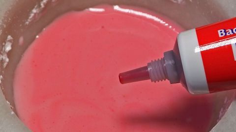 Puderzucker mit einigen Tropfen Lebensmittelfarbe so lange vermengen, bis der Puderzucker gleichmäßig durchgefärbt und trocken ist, eventuell noch etwas Puderzucker unterrühren.