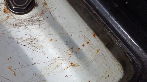 Mit heißem Wasser und einem Geschirrspültab eingebranntes Backofenfenster reinigen.
