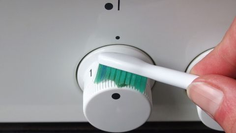 Die Schalter eines Elektroherds lassen sich mithilfe von Glasreiniger und einer Zahnbürste reinigen.