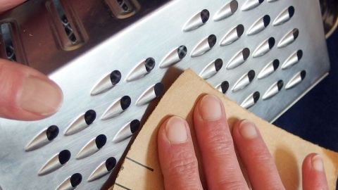 Stumpf gewordene Küchenreibe mit Sandpapier schärfen.