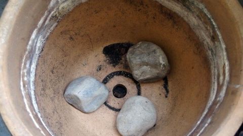 Auf den Boden von großen Blumentöpfen Steine zum Beschweren geben.