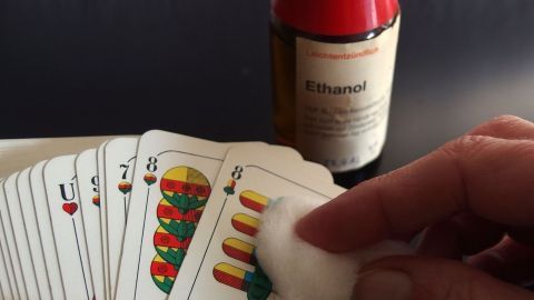 Spielkarten mit einem in Alkohol getränkten Wattebausch reinigen.