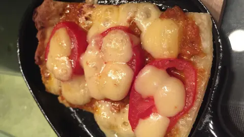 Das Pizzastück im Raclette überbacken, bis der Käse schön verlaufen ist.