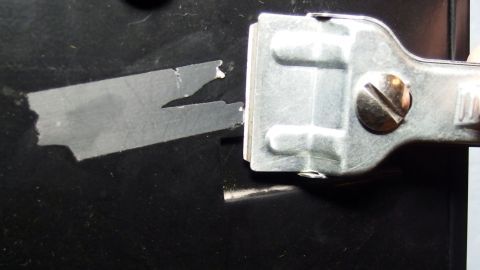 Mit einem Glaskeramikfeldschaber Klebereste vom Briefkasten entfernen.