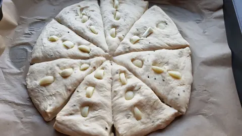 Der Teig wird vor dem Backen unterteilt: So entsteht die charakteristische Form des römischen Brotes.