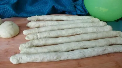 Hier siehst du den frischen Bärlauch-Teig in Stangenform, bereit zum Formen der Knopf-Brötchen aus dem Rezeptartikel.