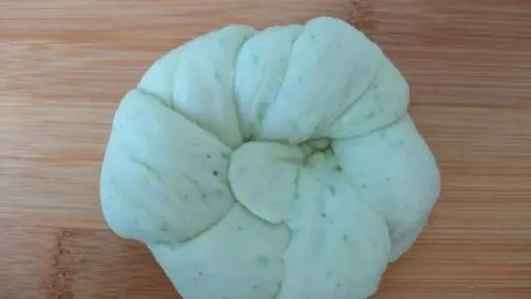 Der fertige Teigling kommt gemeinsam mit den anderen Brötchen auf ein Backblech.