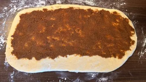 Welle den Hefeteig aus und bestreiche ihn mit der leckeren Spekulatius-Zimt-Füllung. Auf den ausgewellten Hefeteig kommt die leckere Spekulatius-Zimt-Füllung.