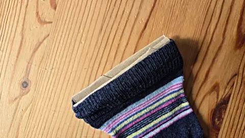 Mit einem Stück Karton kannst du den Bund deiner Socken weiten und so unangenehme Druckstellen vermeiden.