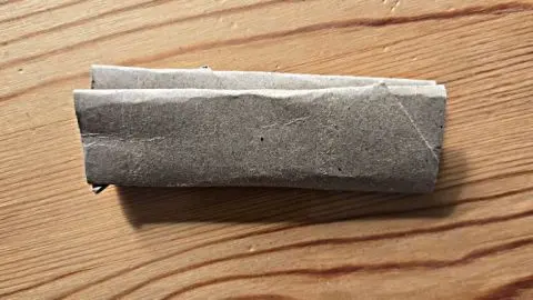 Mit einer einfachen Papprolle, wie im Bild, kannst du den Sockenbund weiten und Druckstellen an den Knöcheln vermeiden.