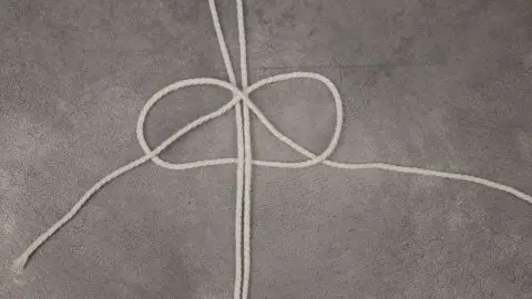 So bindest du den ersten Knoten für ein Makramee-Skelett, perfekt als DIY-Halloweendeko laut Anleitung im Artikel.