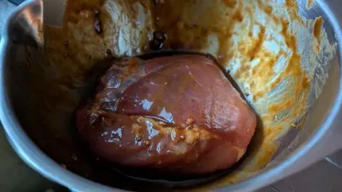 Schinkenbraten auf Kartoffel Gemüsebett: Hier habe ich meinen Schinkenbraten in der Marinade durchziehen lassen. Schinkenbraten auf Kartoffel-Gemüsebett: Der Braten mariniert in würziger Sauce im Topf – so startest Du die Vorbereitung.