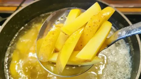 Einfache Steakhouse-Fries mit Schale: Die Kartoffelspalten werden im hei&szlig;en &Ouml;l knusprig ausgebacken &ndash; so gelingen Dir Steakhouse-Pommes wie im Restaurant.