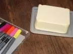 Mit Butter gegen Lackmalstiftflecken auf Holztisch