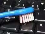PC-Tastatur mit leicht feuchter Zahnbürste reinigen