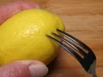 Nur ein paar Tropfen Zitronensaft - Zitrone mit Gabel anstechen