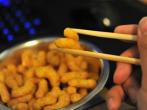 Erdnussflips-Locken am Computer essen