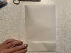 Das Butterbrotpapier so drehen, dass es hochkant liegt und von unten ca. 4 cm nach oben klappen, die Kante glattstreichen und wieder zurückklappen.