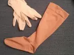 Kompressionsstrumpf mithilfe von Einmalhandschuhen anziehen