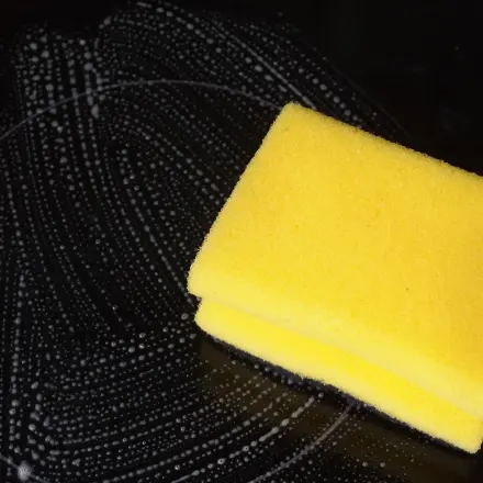 Glaskeramikfeld mit Spülmittel und Topfreinigern reinigen