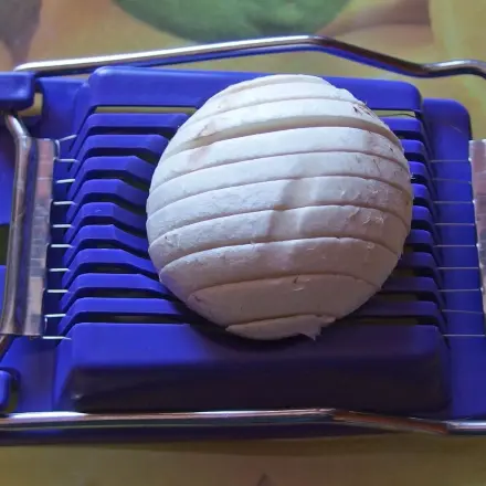 Champignons mit dem Eierschneider in Scheiben schneiden