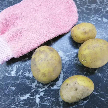 Kartoffeln mit Peelinghandschuhen waschen