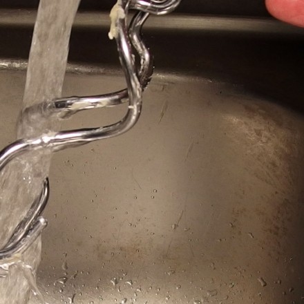 Teigreste an Küchenutensilien & Händen mit kaltem Wasser abwaschen