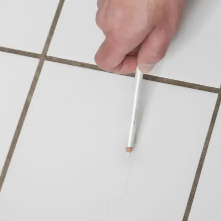 Haarrisse in weißen Wandfliesen kaschieren: mit weißem Kajalstift