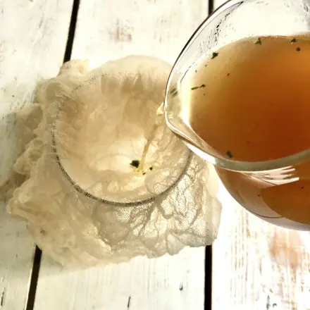 Flüssigkeiten abseihen durch Sieb mit Stoffwindel