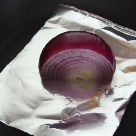 Zwiebeln bräunen in der Pfanne mit Alufolie