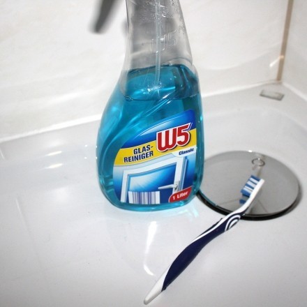 Zahnbürste und Glasspray zum Dusche putzen