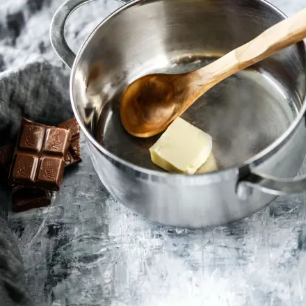 Schokolade direkt im Topf schmelzen - erst mit Butter ausstreichen