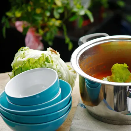 Zu viel Fett auf Suppe oder Eintopf entfernen: mit Salatblättern