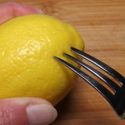 Nur ein paar Tropfen Zitronensaft - Zitrone mit Gabel anstechen
