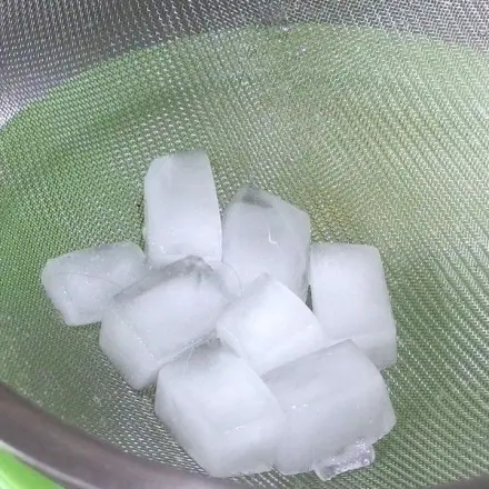 Eiswürfel auf Parties halten länger in einem Sieb über einer Schüssel