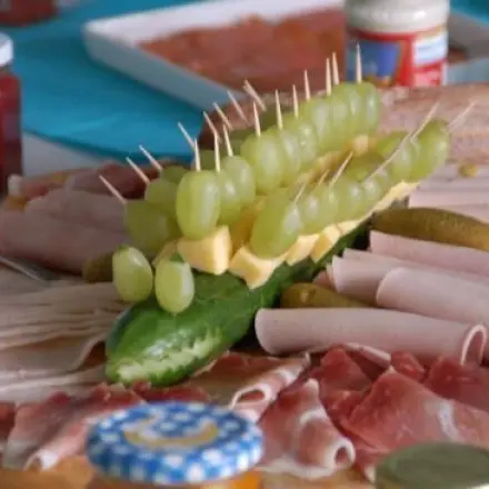 Gurkenkrokodil bewacht kaltes Buffet