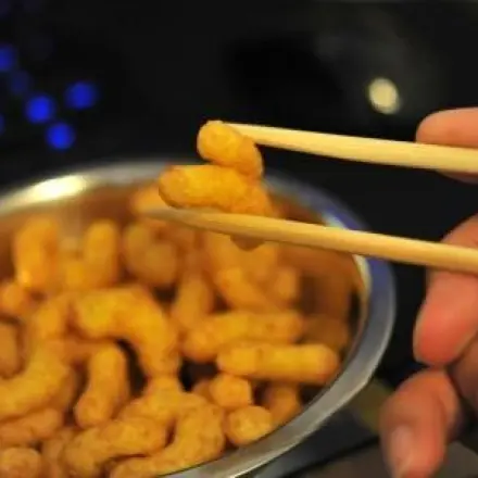 Erdnussflips-Locken am Computer essen