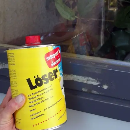 Kleberreste an Fensterrahmen mit "Teppichkleberreste-Entferner"