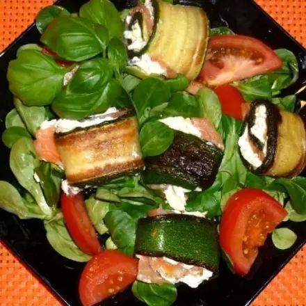 Feldsalat mit gebratenen, gefüllten Zucchinirollen