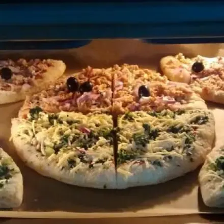 Zwei Tiefkühlpizzen auf einem Blech aufbacken