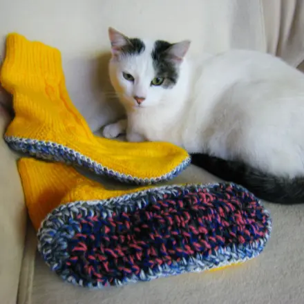 Gestrickte Socken mit dicken Sohlen als Hausschuhe