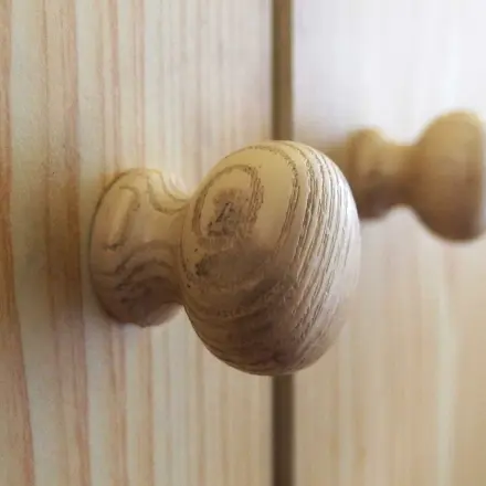 Ausgefranste Löcher im Holzknauf von Schrank oder Schublade