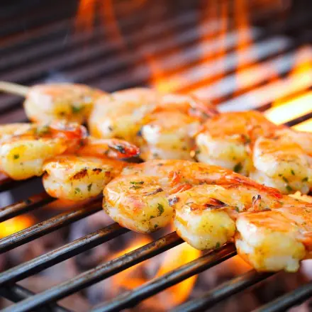 Auf dem Grill: Kleine Würstchen oder Garnelen einfach wenden