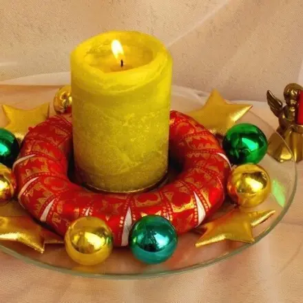 Adventsdeko mit umwickeltem Kranz, Kugeln und Sternen